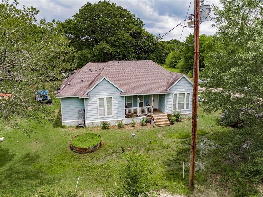 a view of a house with backyard garden and sitting area