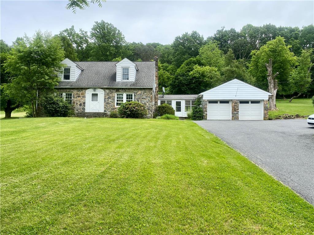 a front view of a house with yard and green space