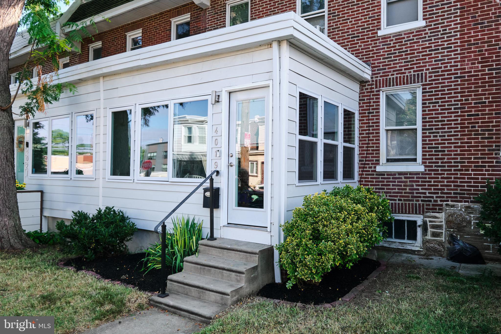 a view of a house with potted plants and a table