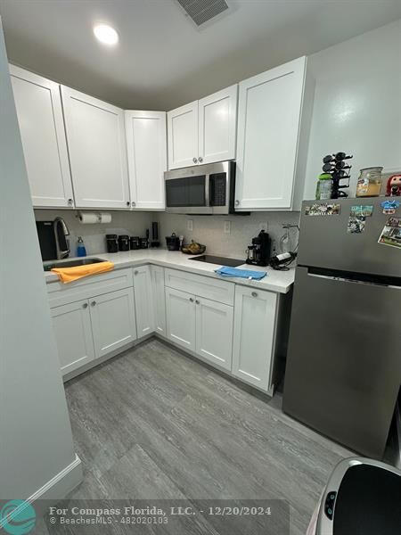 a kitchen with stainless steel appliances granite countertop a sink and cabinets