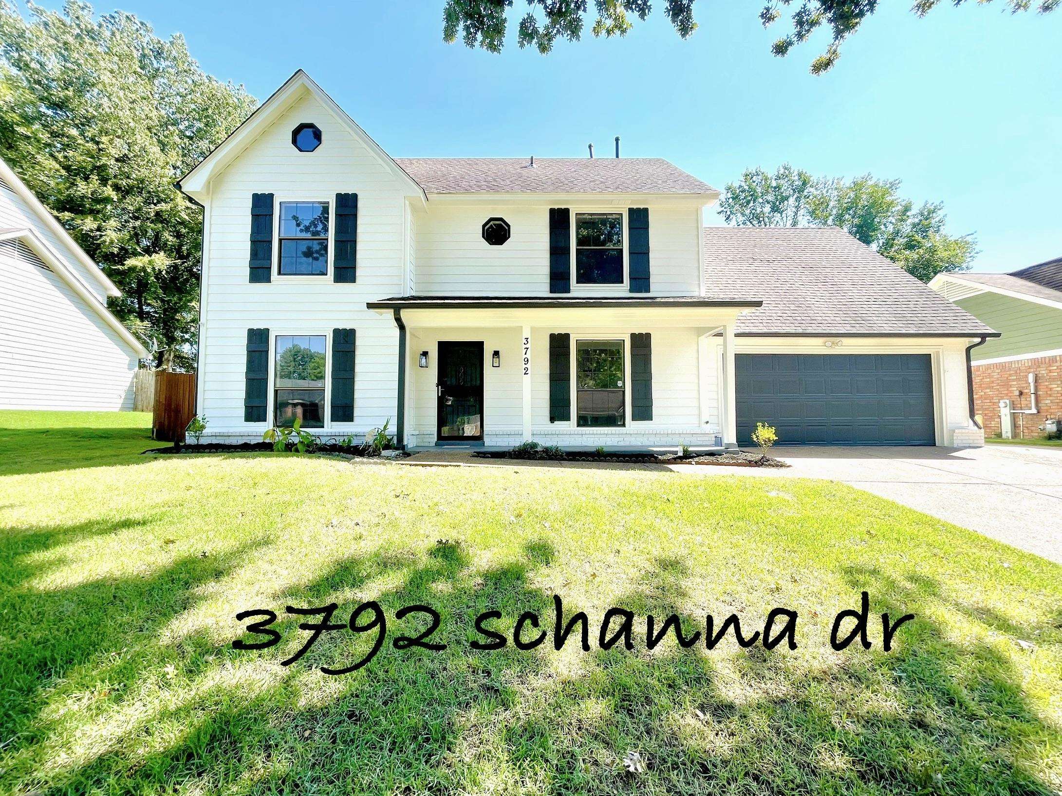 Colonial home with a front lawn, a porch, and a garage