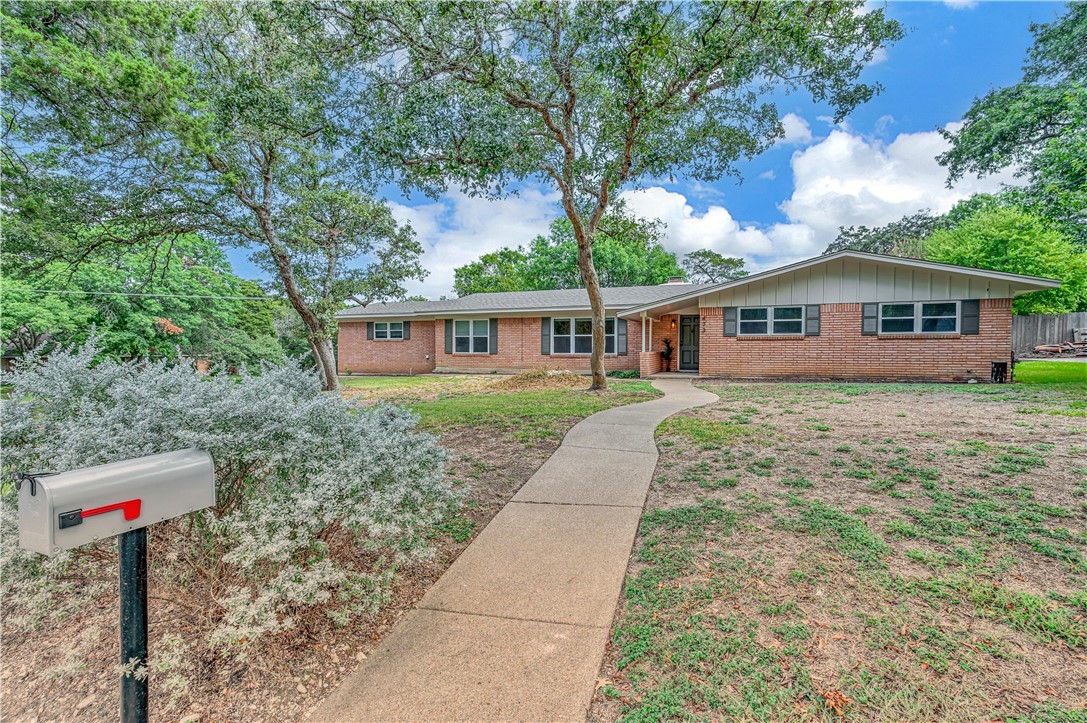 a front view of a house with a yard and trees