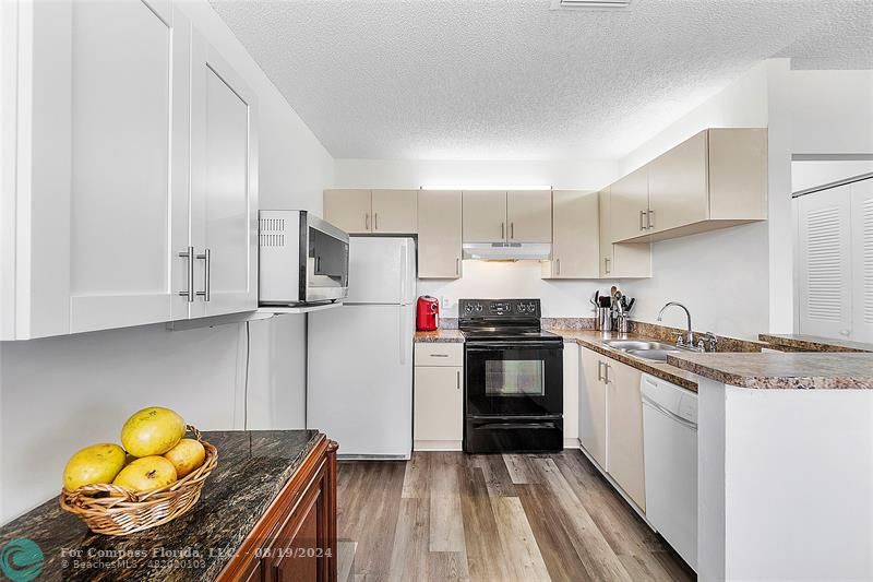 a kitchen with stainless steel appliances granite countertop a sink and a stove