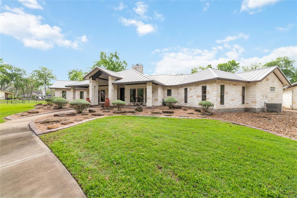 a front view of a house with yard patio and swimming pool