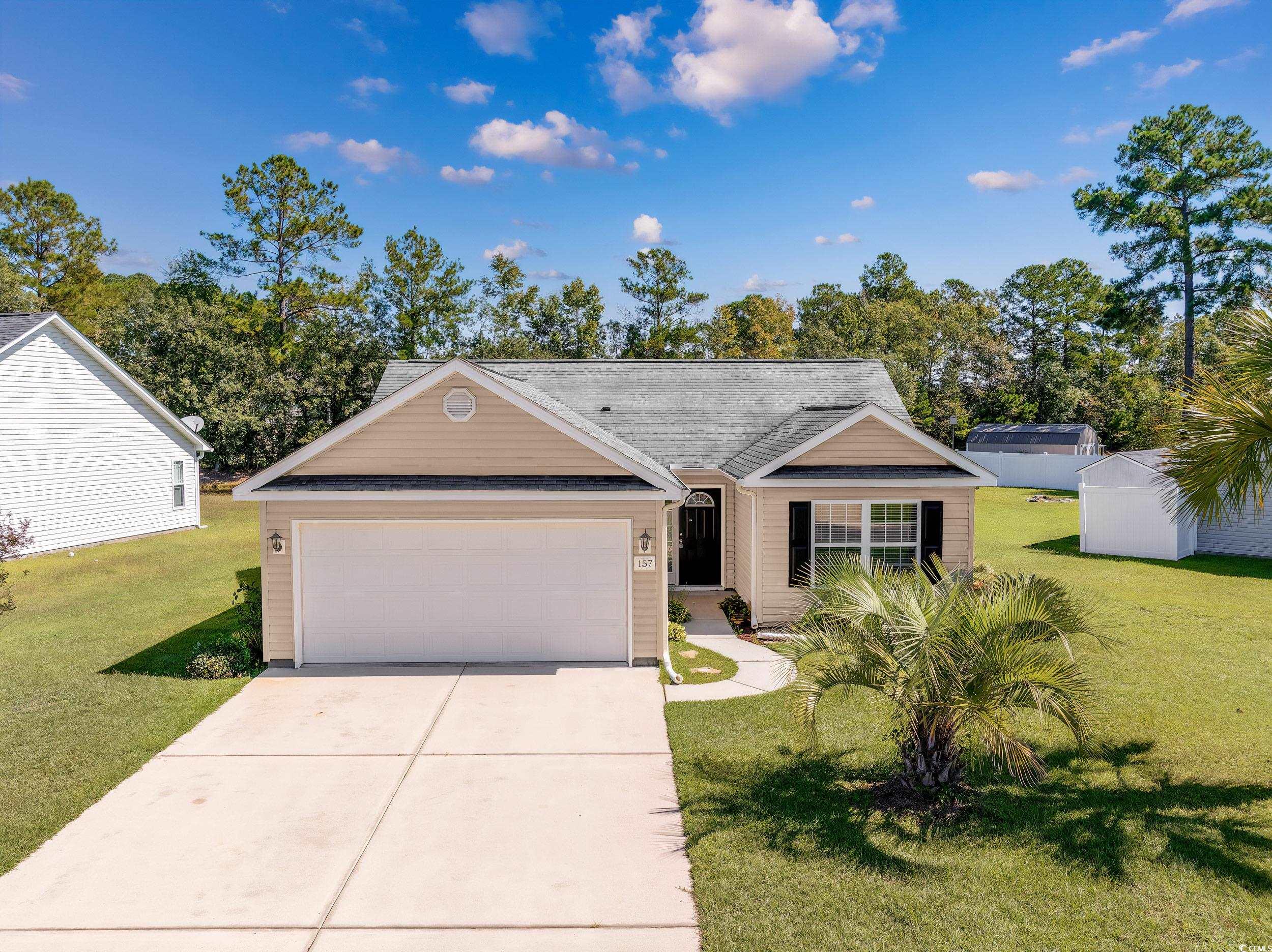 View of front of home with a front lawn and a gara