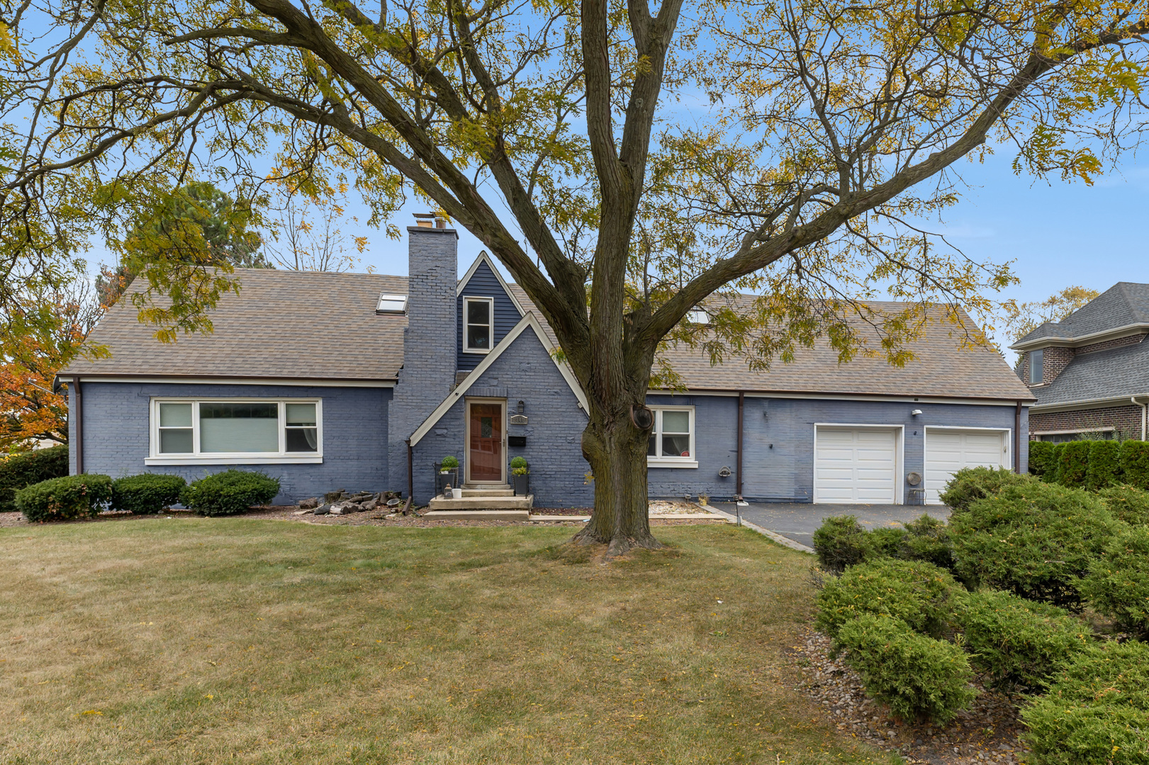 a view of a house with a tree in front of it