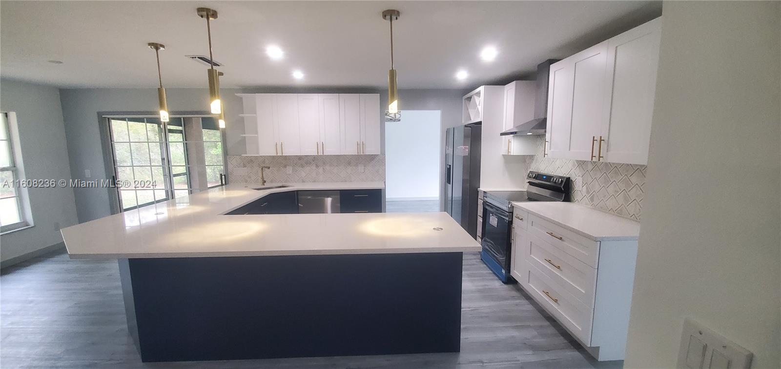 a kitchen with kitchen island sink stove and refrigerator