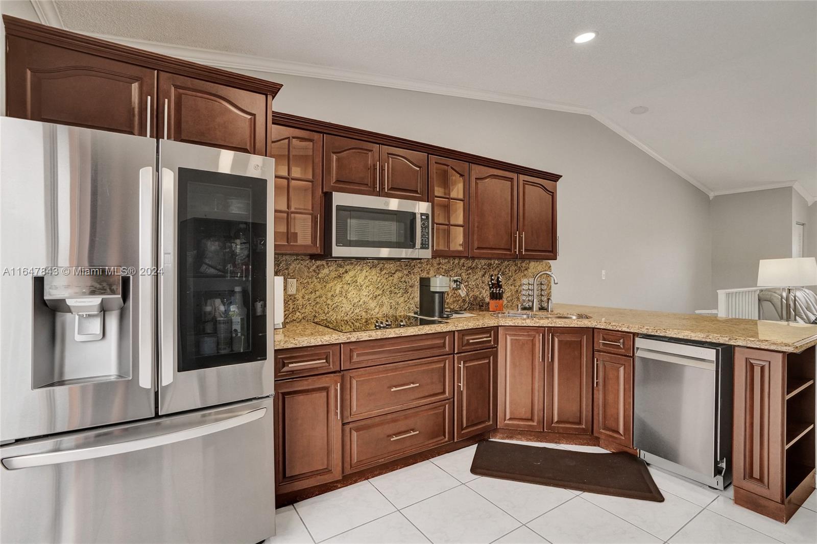 a kitchen with stainless steel appliances granite countertop a refrigerator and a stove top oven