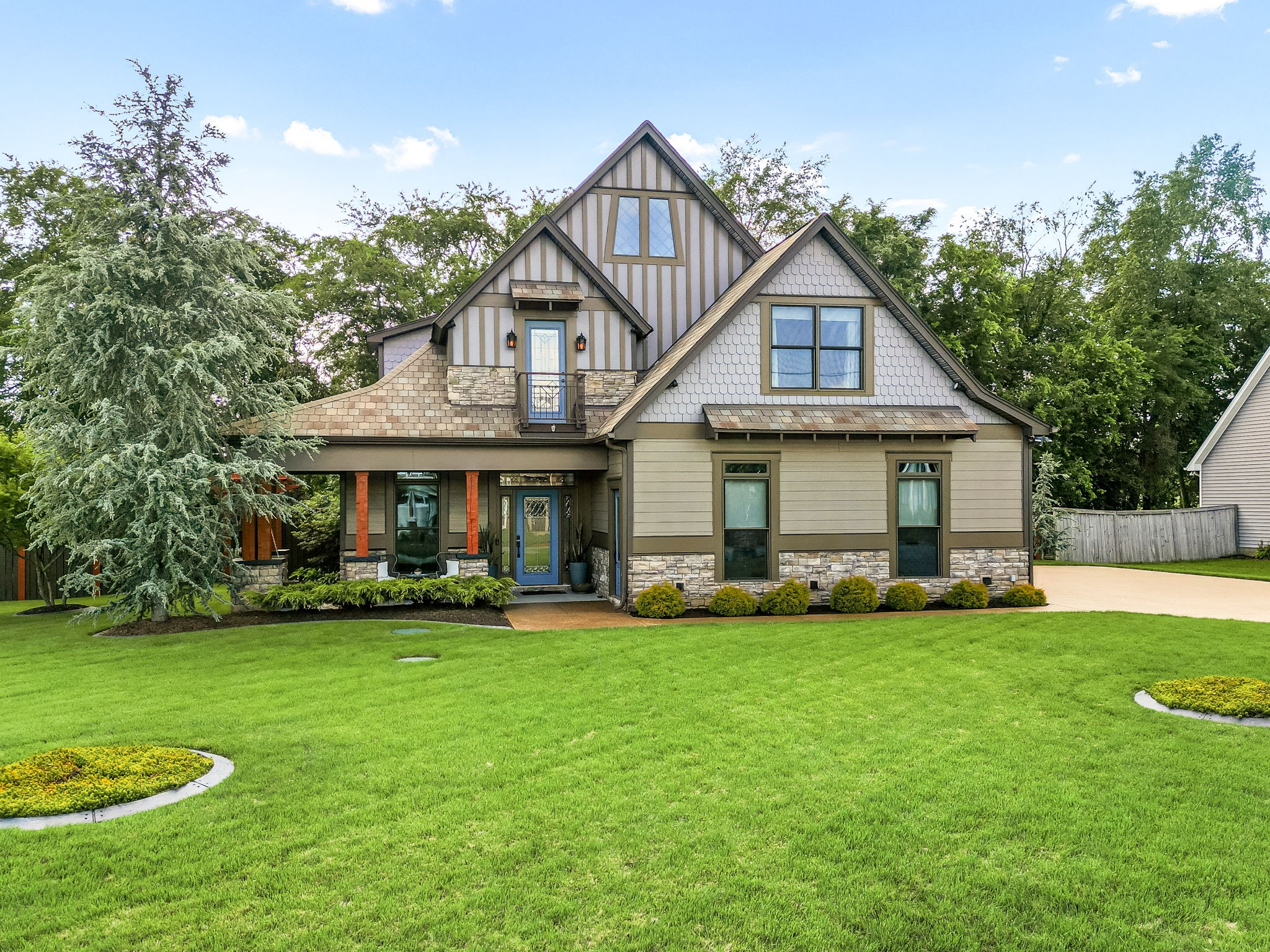 a front view of a house with a garden and trees