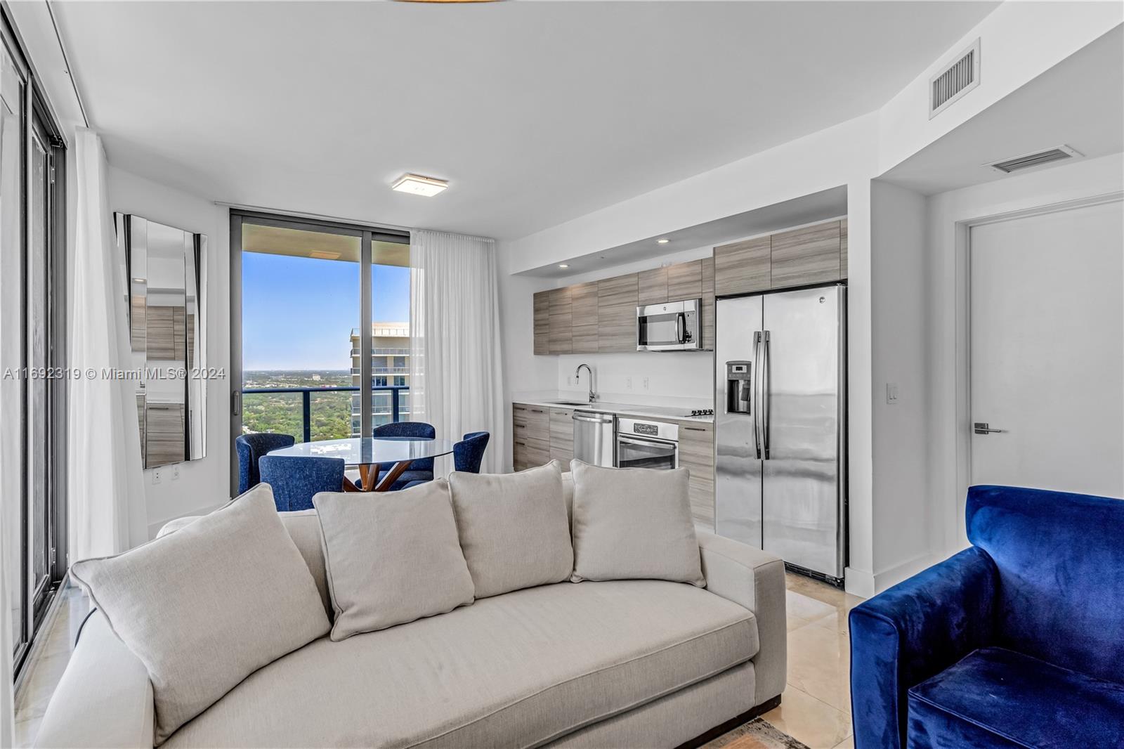 a living room with furniture white walls and a view of kitchen