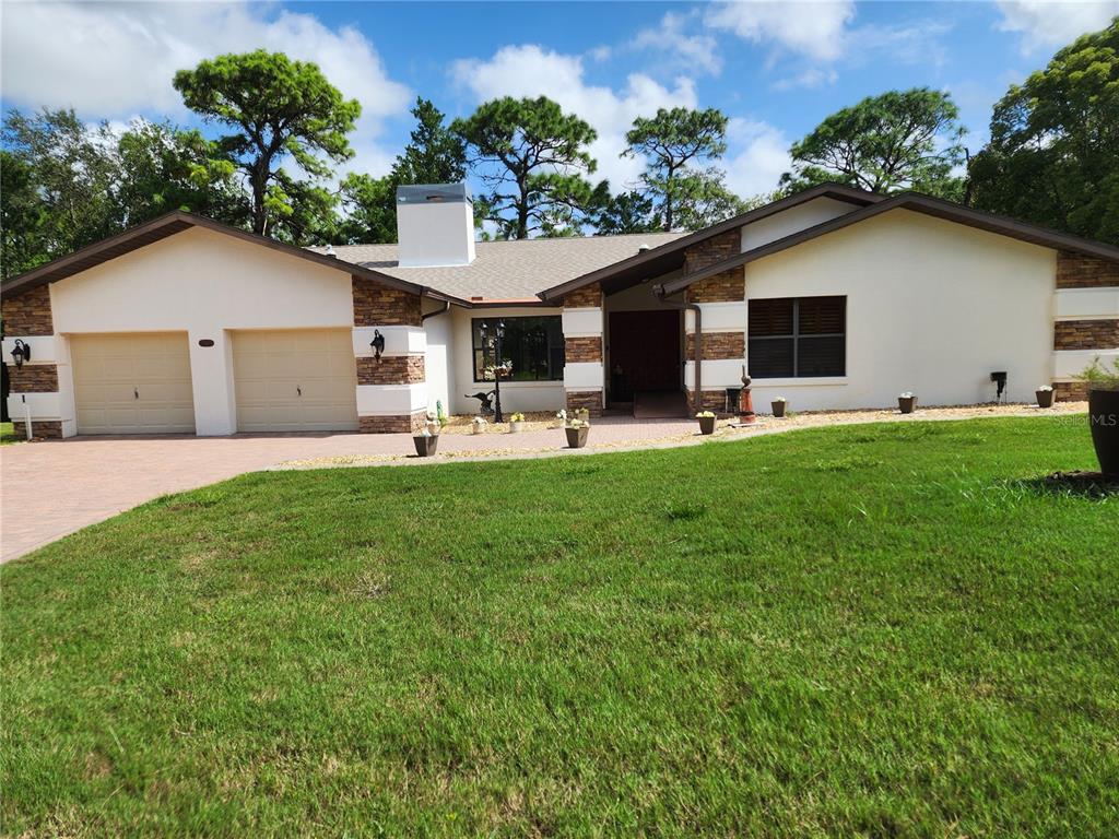 a front view of house with yard and trees