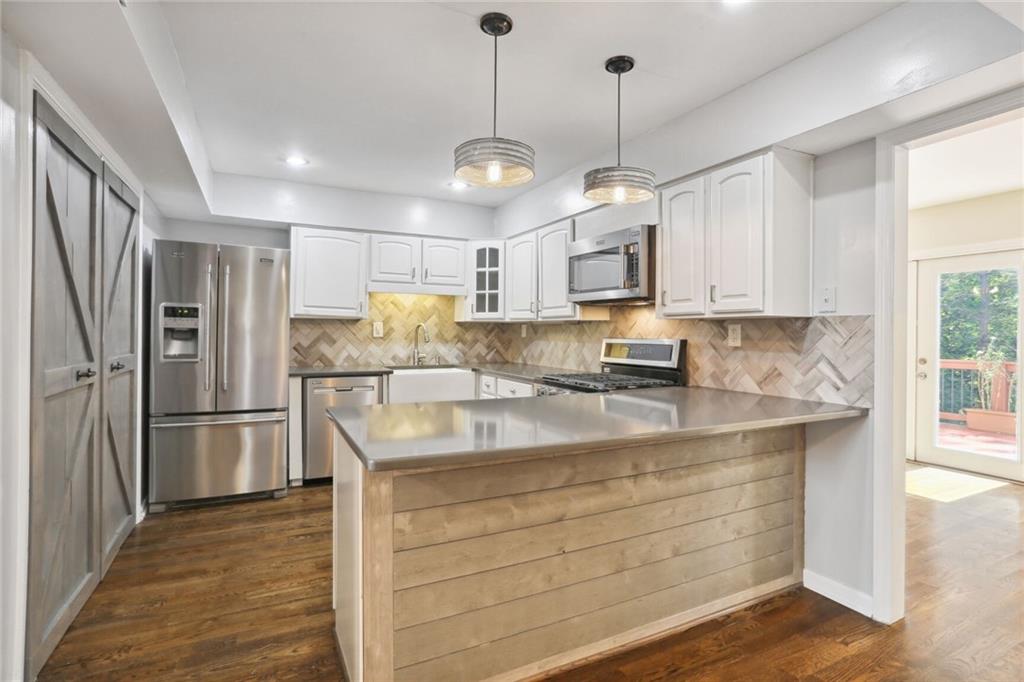 a kitchen with kitchen island a sink stainless steel appliances and window