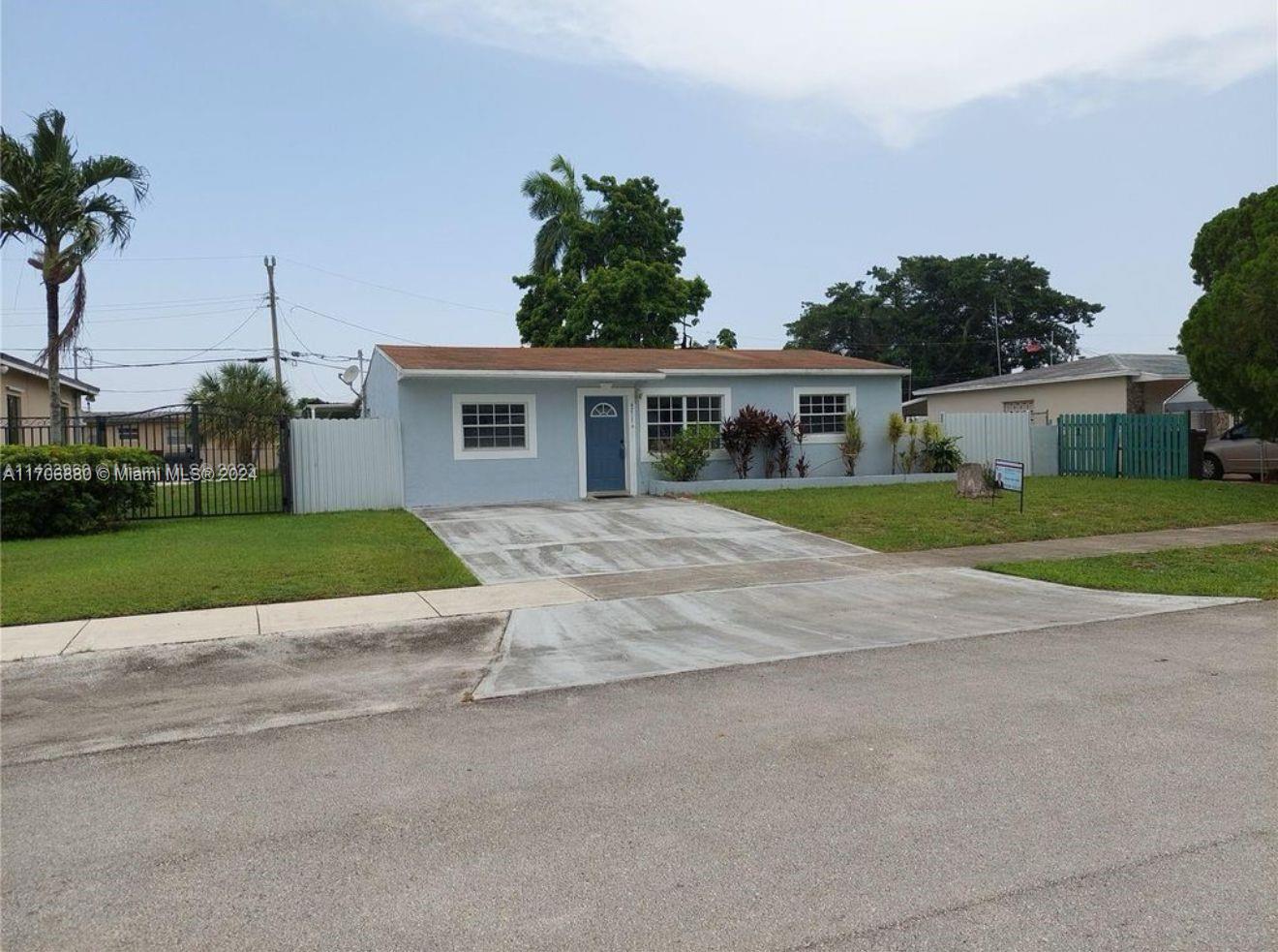 a view of a house with a yard and potted plants