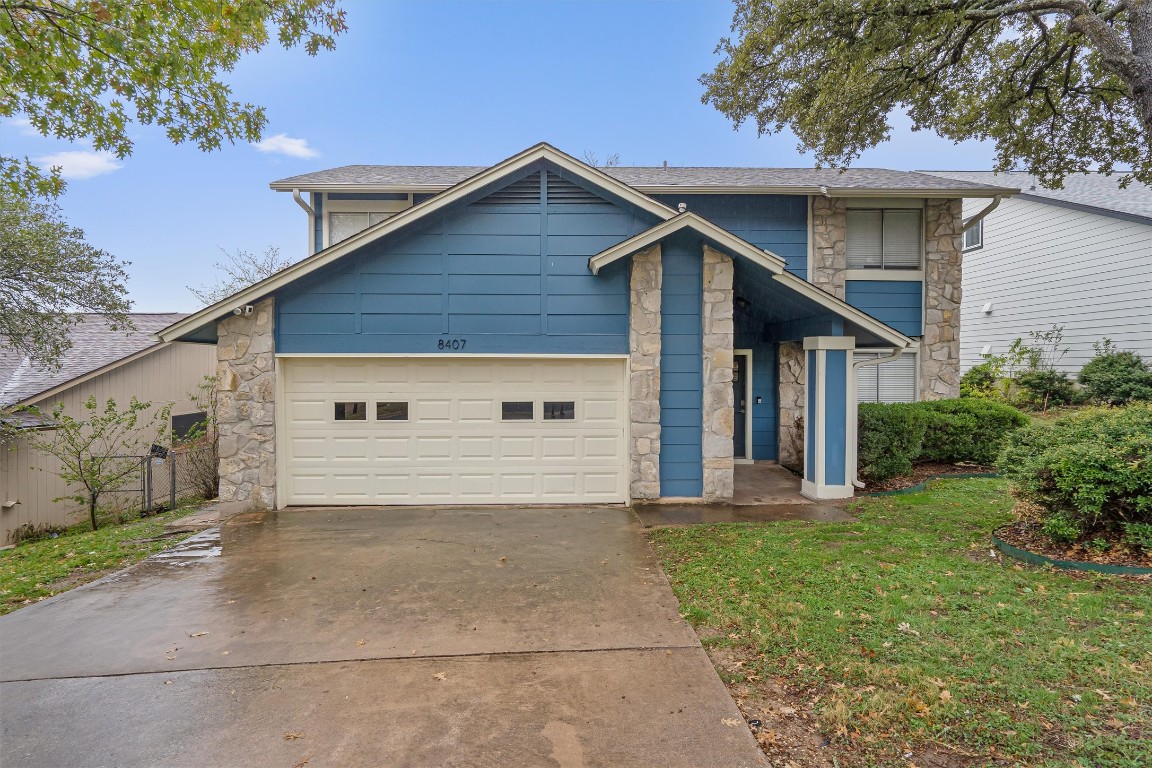 a view of a house with yard and a garage