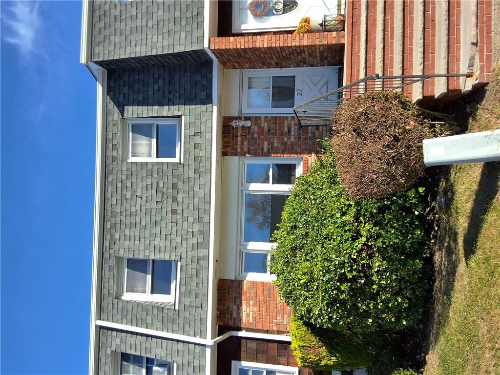 front view of a brick house with a small yard