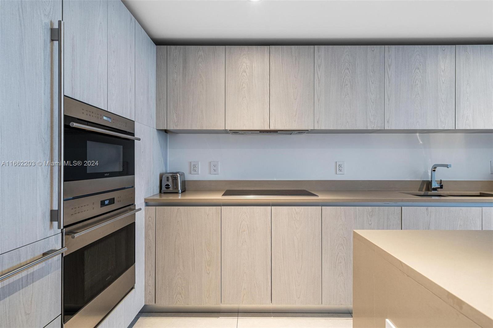 a kitchen with granite countertop white cabinets and stainless steel appliances