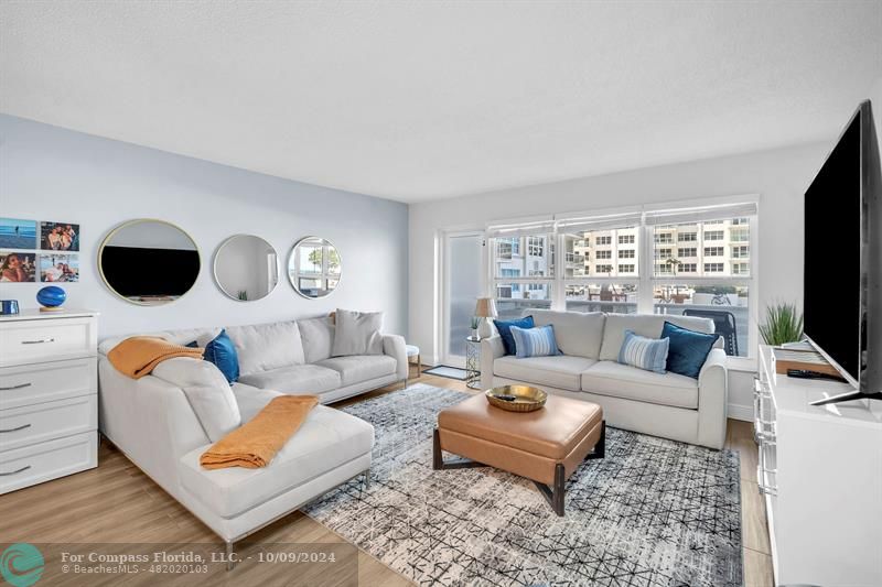 a living room with furniture a flat screen tv and a window