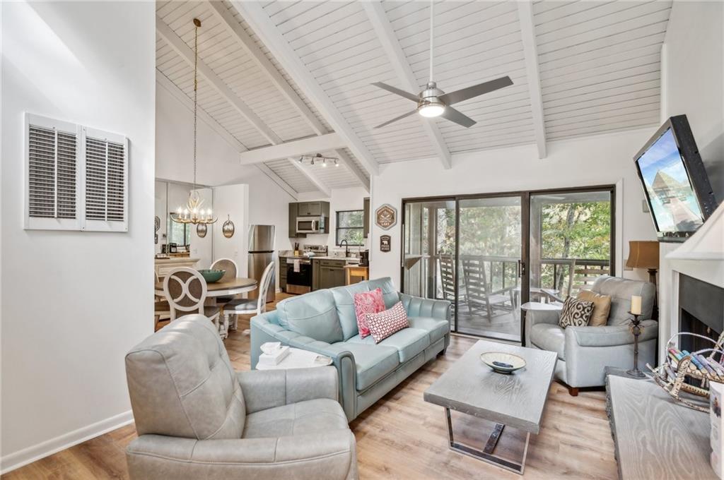 a living room with furniture a flat screen tv and a large window