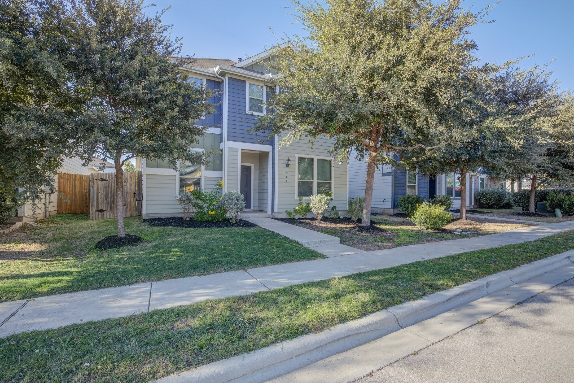 a view of a house with a yard and tree s