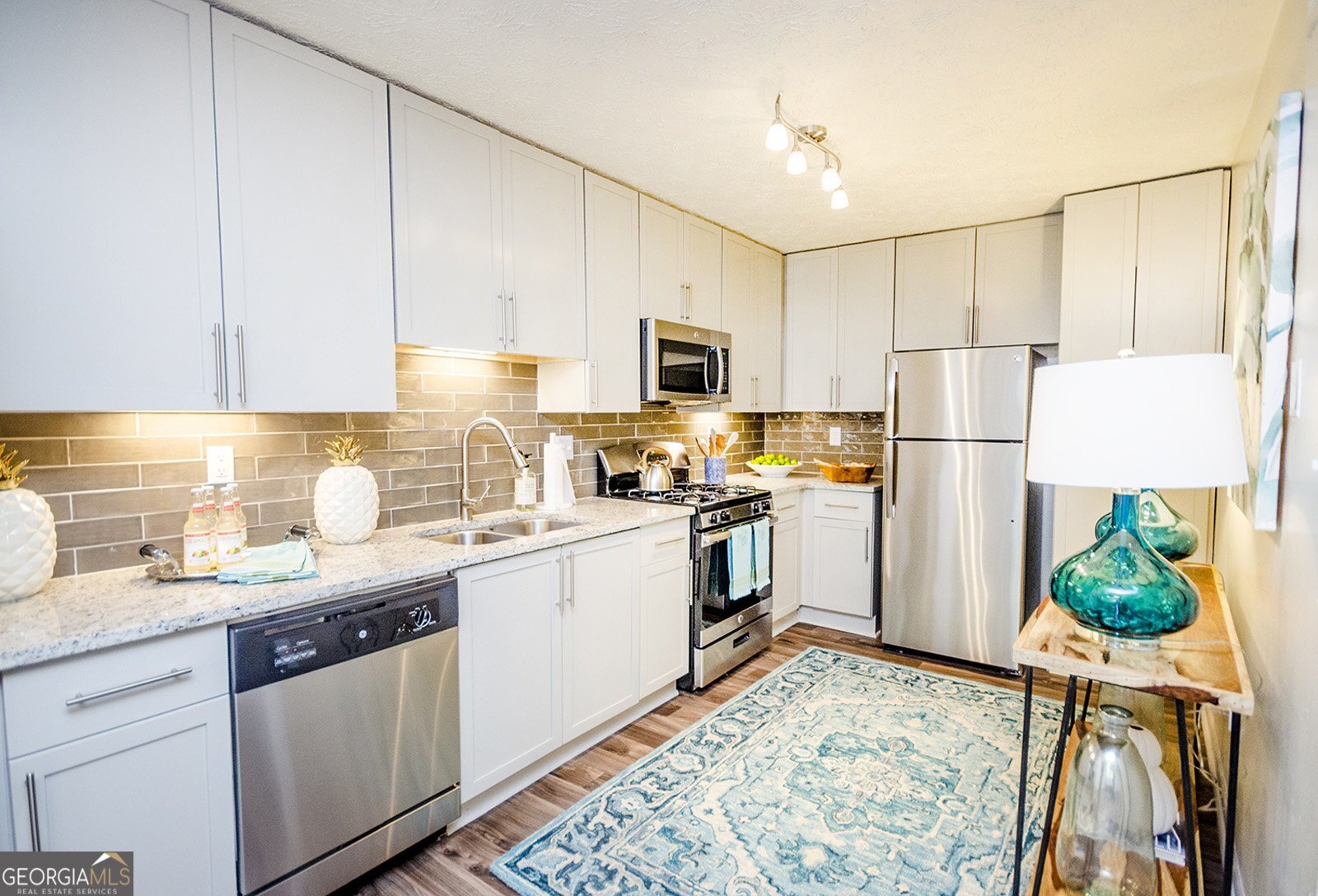 a kitchen with a sink a refrigerator and a stove top oven