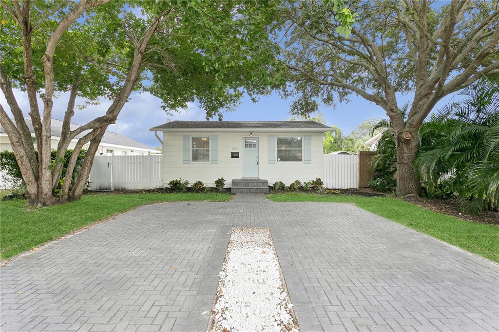 front view of house with a yard and trees