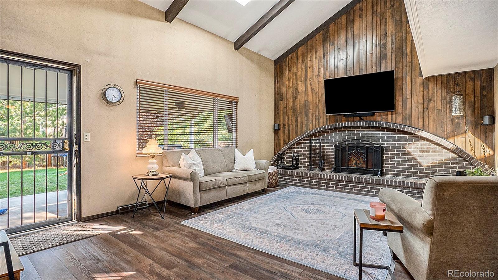 a living room with furniture a flat screen tv and a fireplace