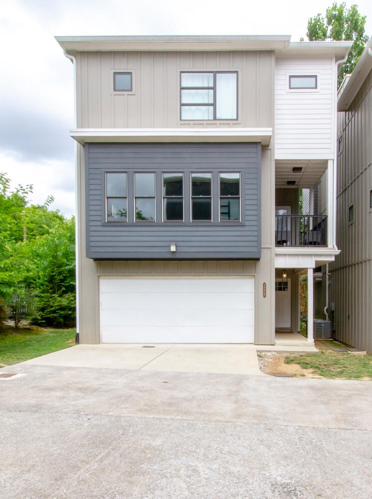 a front view of a house with a garden and garage