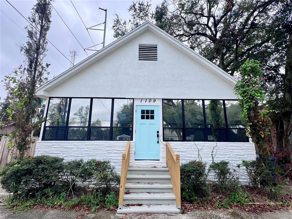 a front view of a house with a yard and potted plants