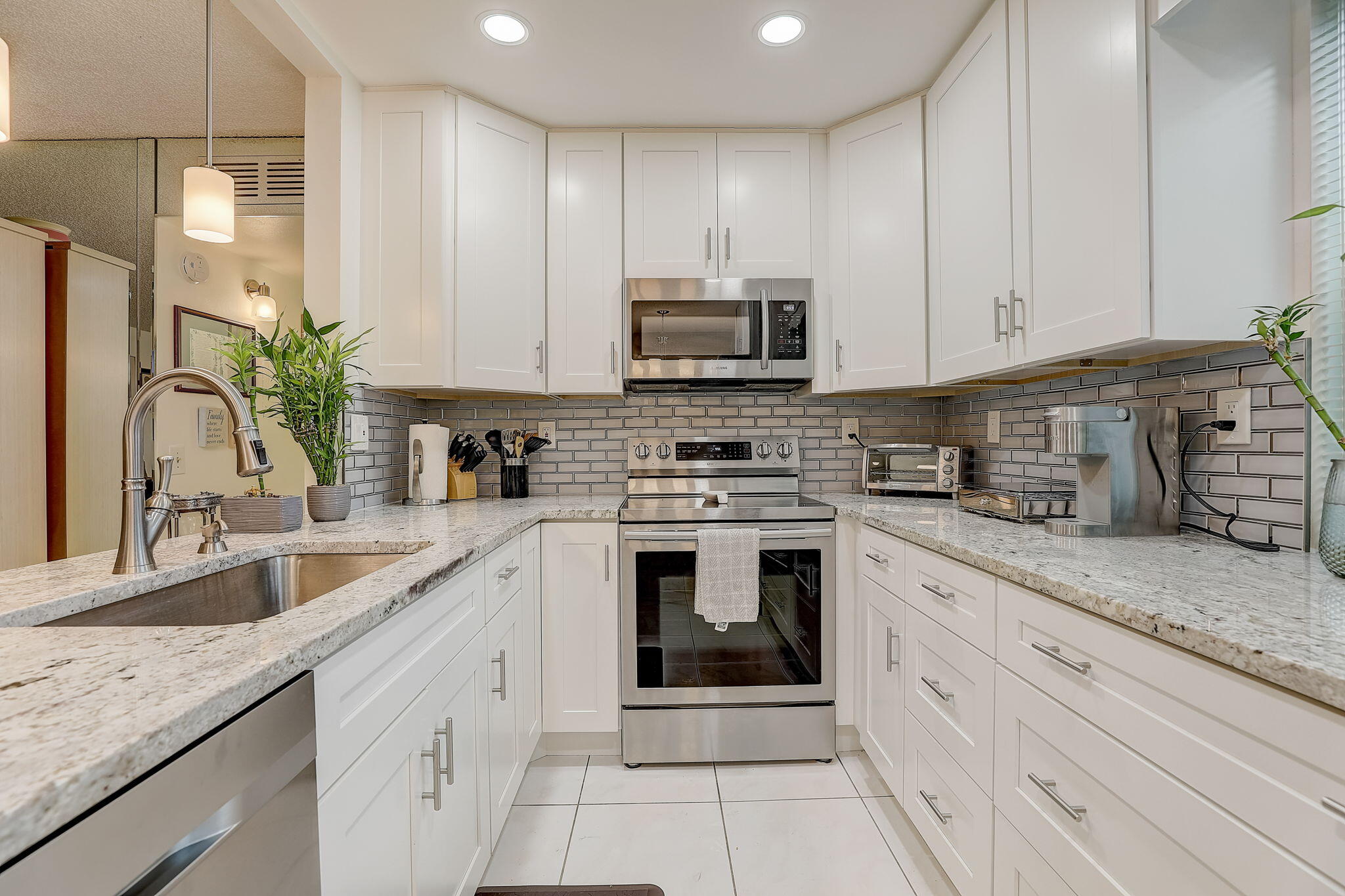 a kitchen with granite countertop a sink stainless steel appliances and cabinets