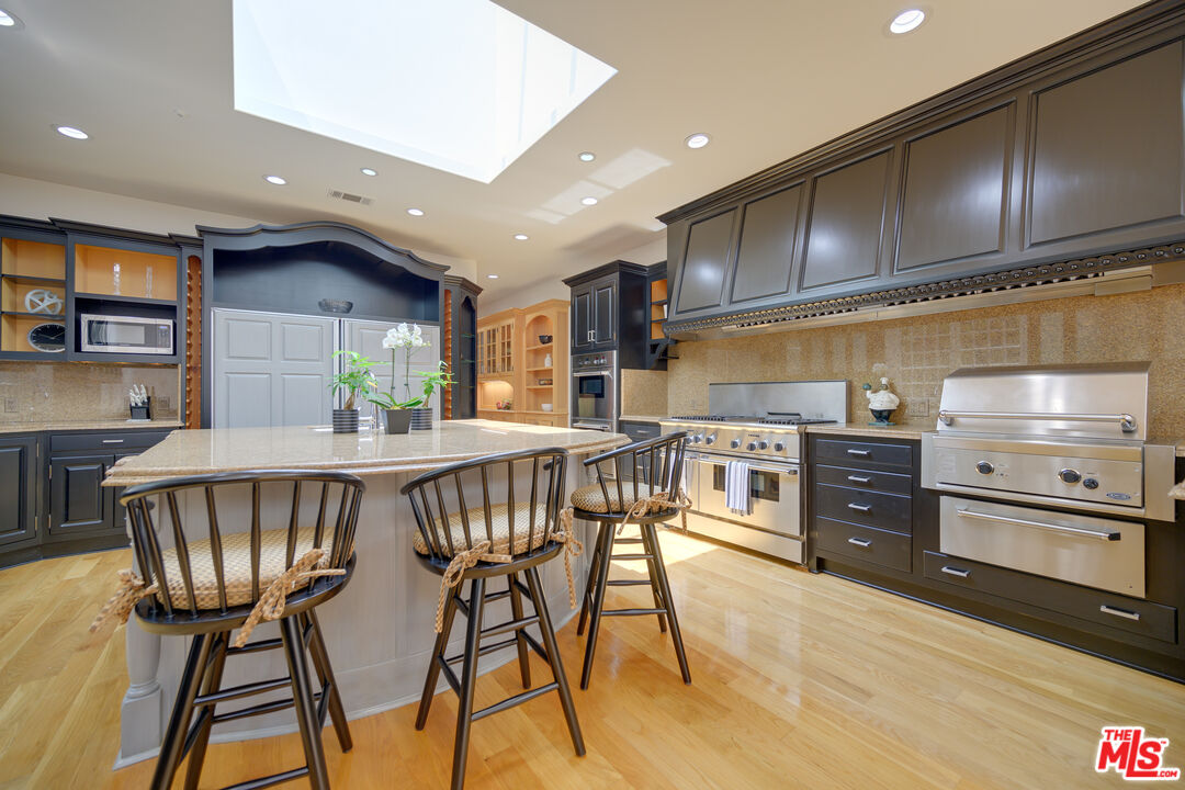 a kitchen with stainless steel appliances wooden floor dining table and chairs