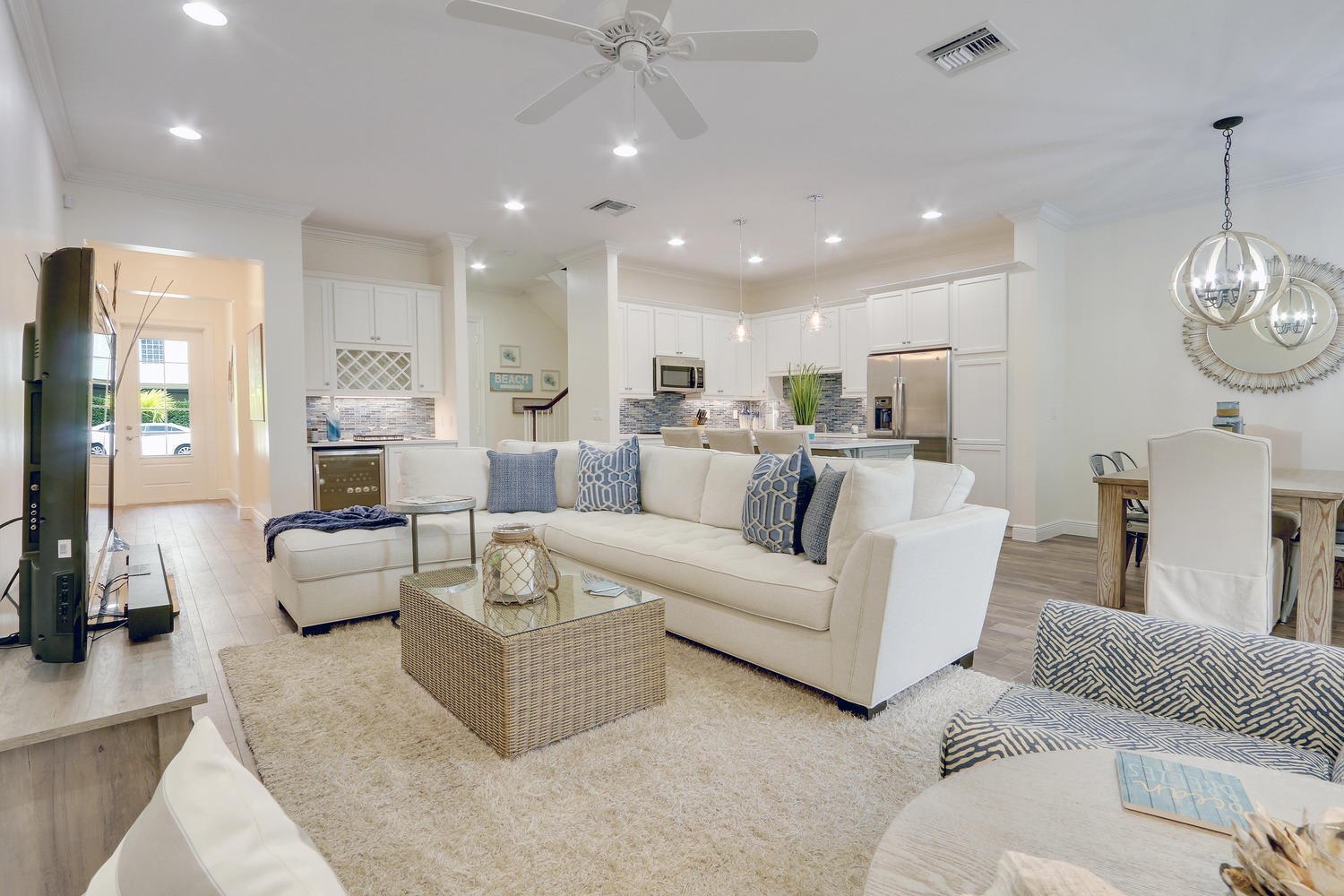 a living room with furniture kitchen view and a chandelier