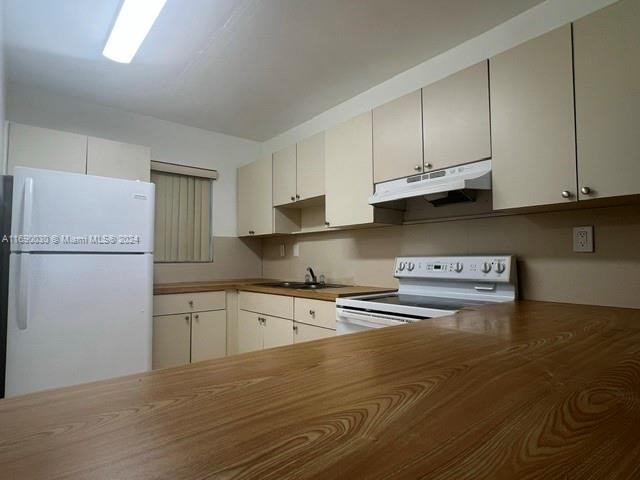 a kitchen with stainless steel appliances granite countertop a refrigerator sink and white cabinets