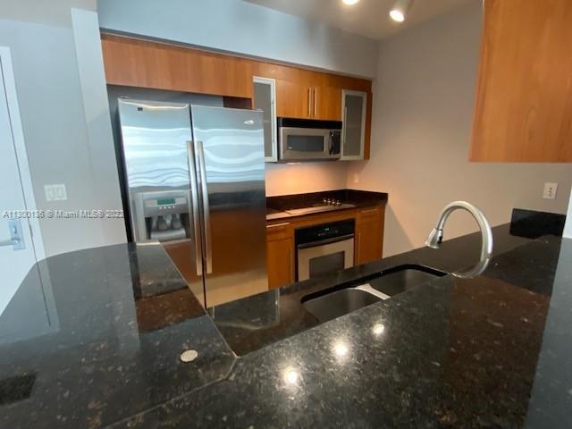 a kitchen with stainless steel appliances a sink stove and refrigerator