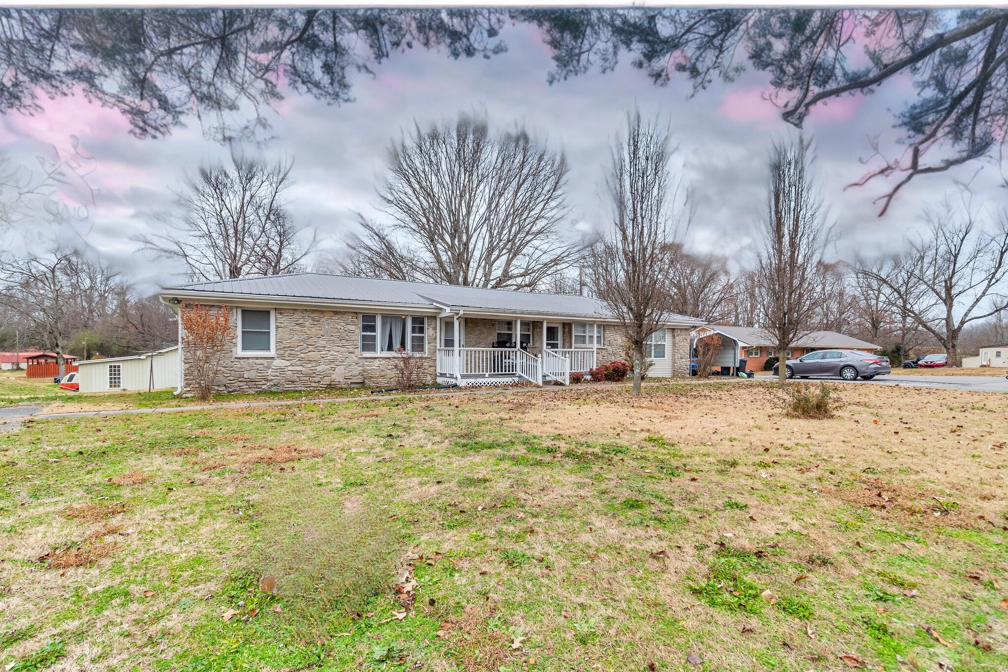 a front view of a house with a yard and trees