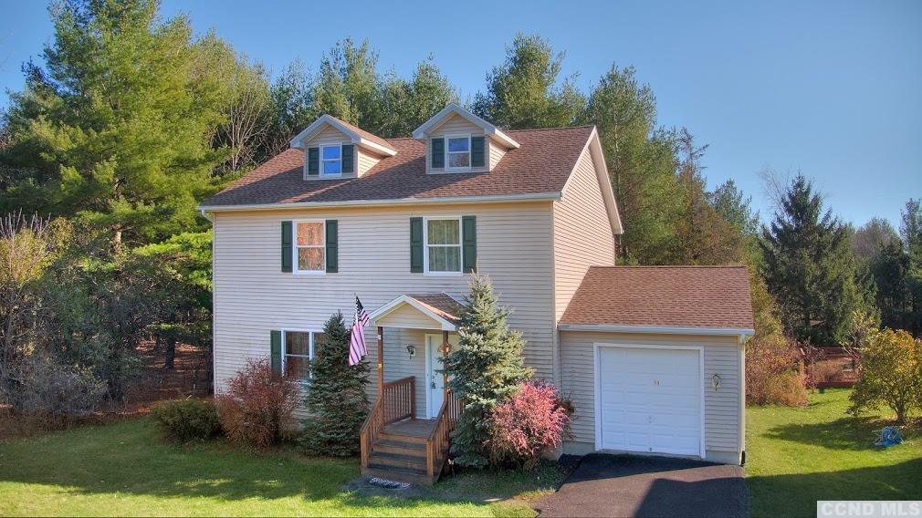 a front view of a house with a yard garage and outdoor seating