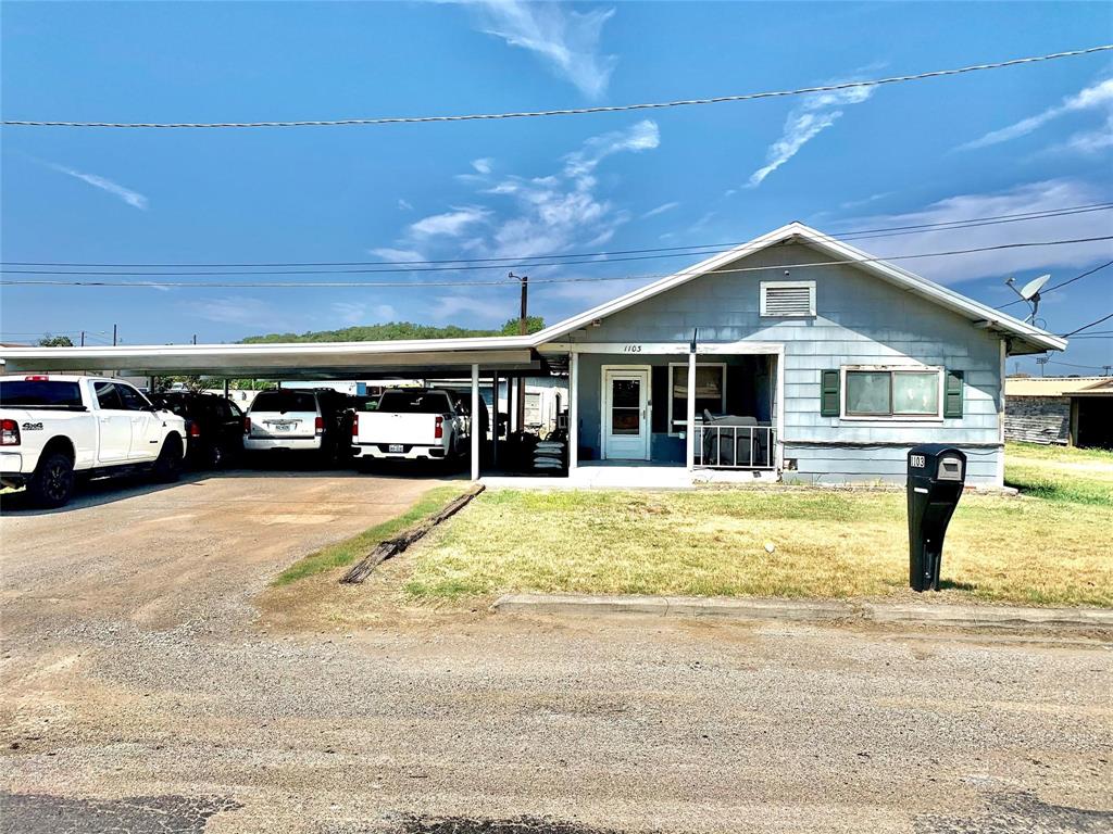 a front view of a house with a garden and car parked