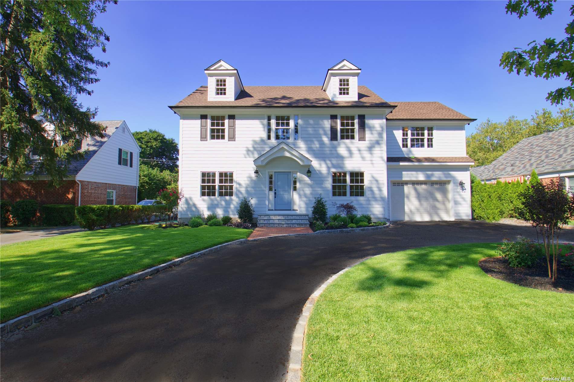 a front view of a house with a garden and plants