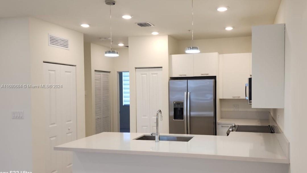 a view of a kitchen with a refrigerator and a counter top space