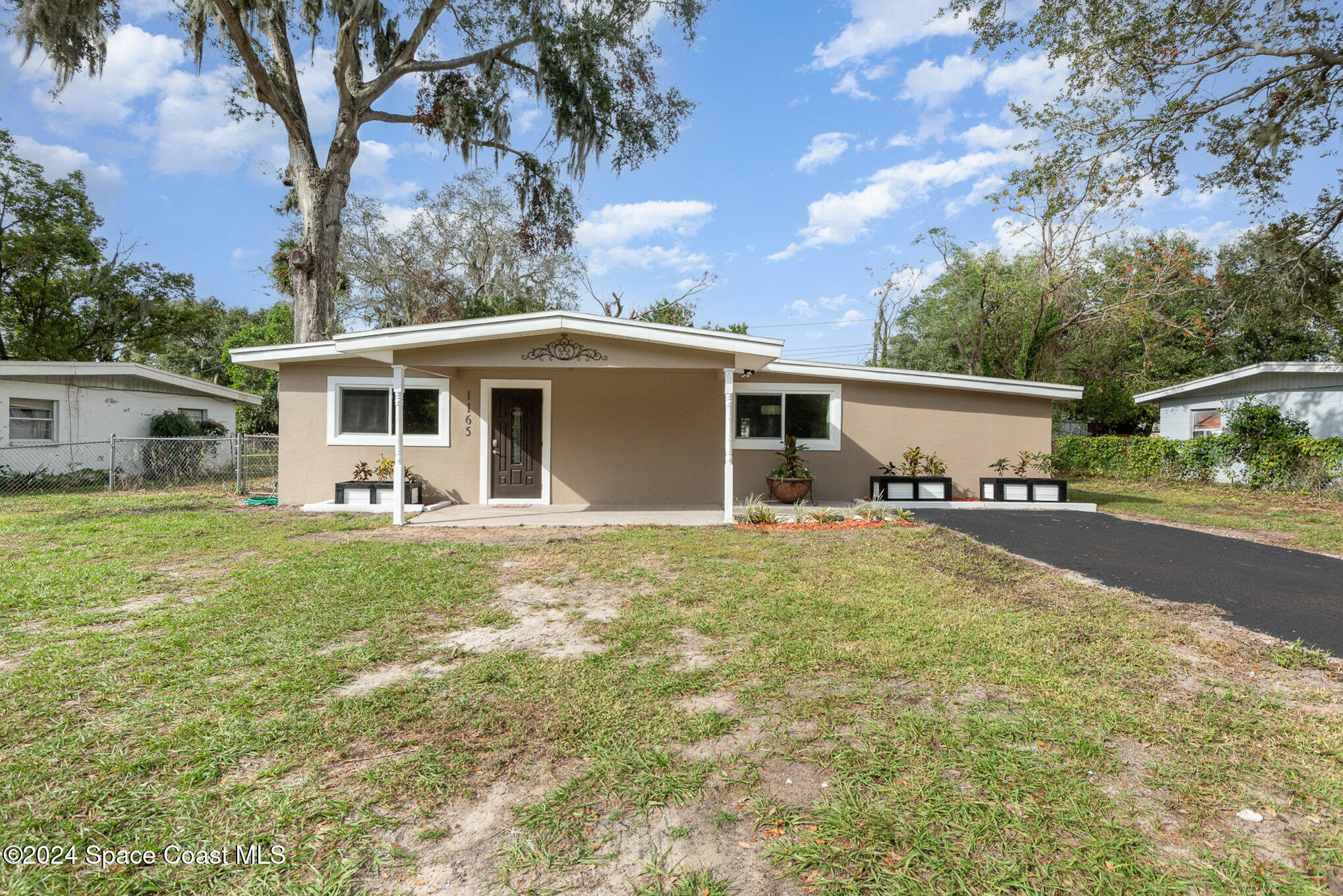 a front view of house with yard and trees in the background