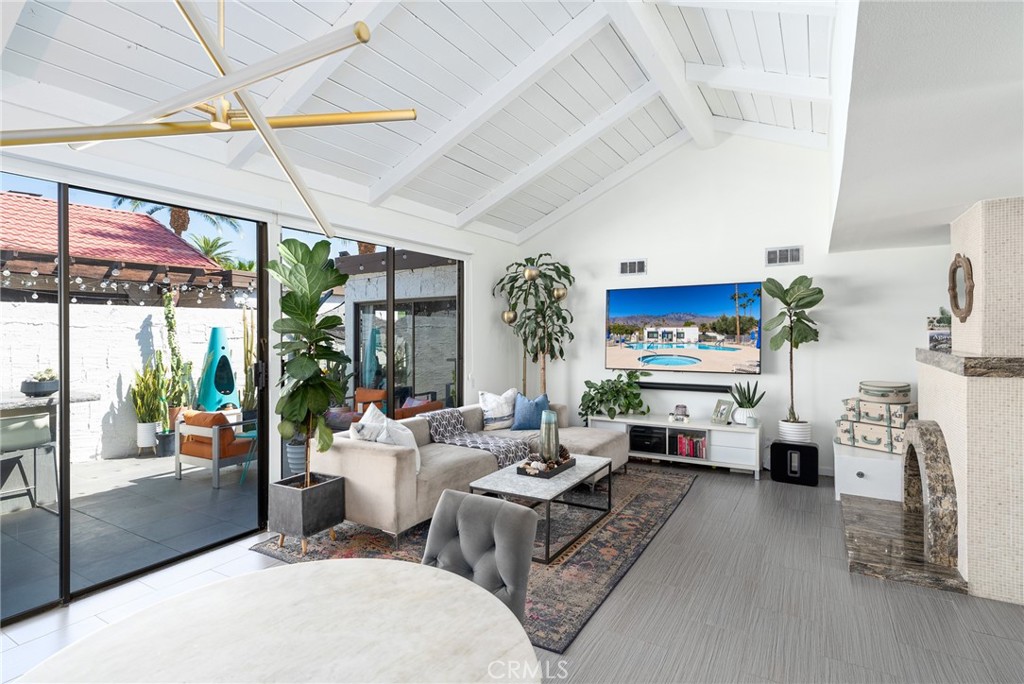 a living room with furniture a fireplace and a chandelier