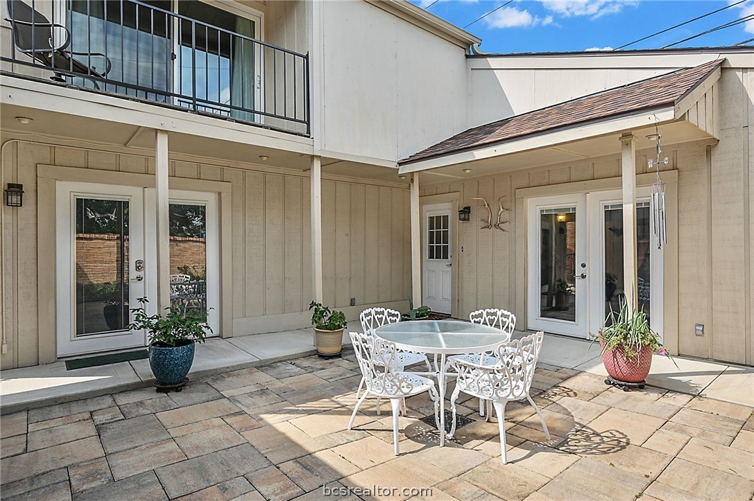 a view of a patio with table and chairs and potted plants