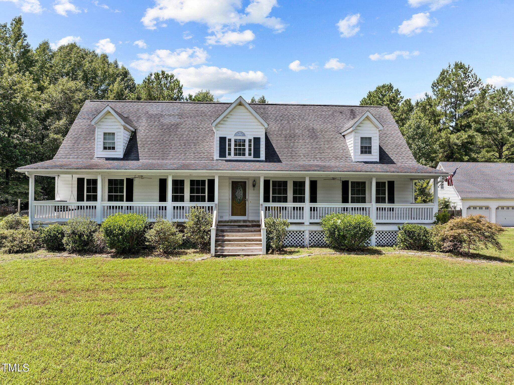 a front view of a house with yard and green space