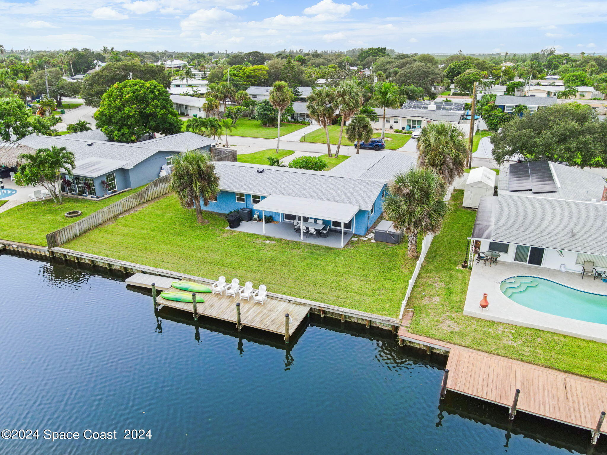 an aerial view of a house with a garden and lake view