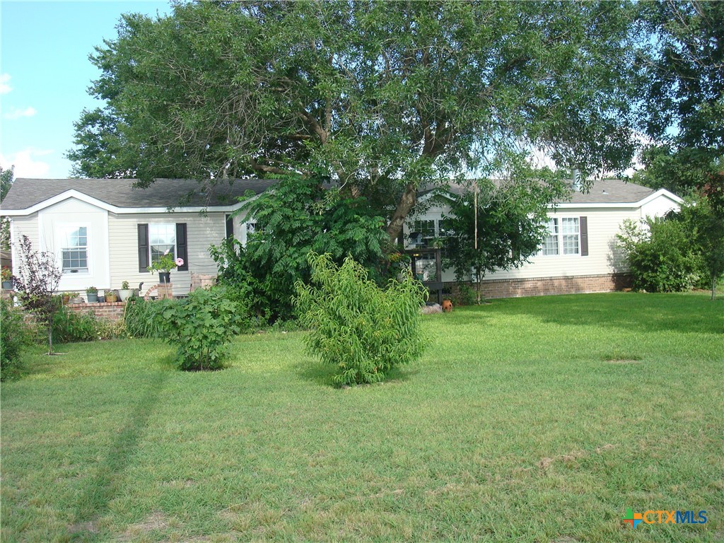 a front view of a house with a yard and trees