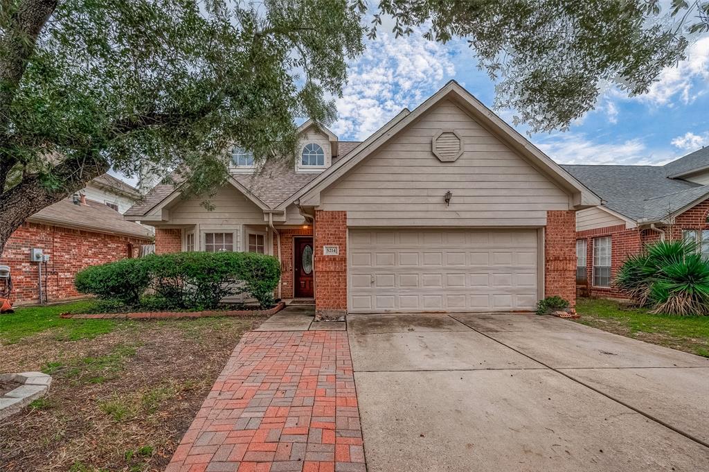 Charming single-story home featuring brick facade, an attached two-car garage, and mature landscaping. The covered entryway and inviting front door welcome you to a cozy residence set in a tranquil neighborhood.