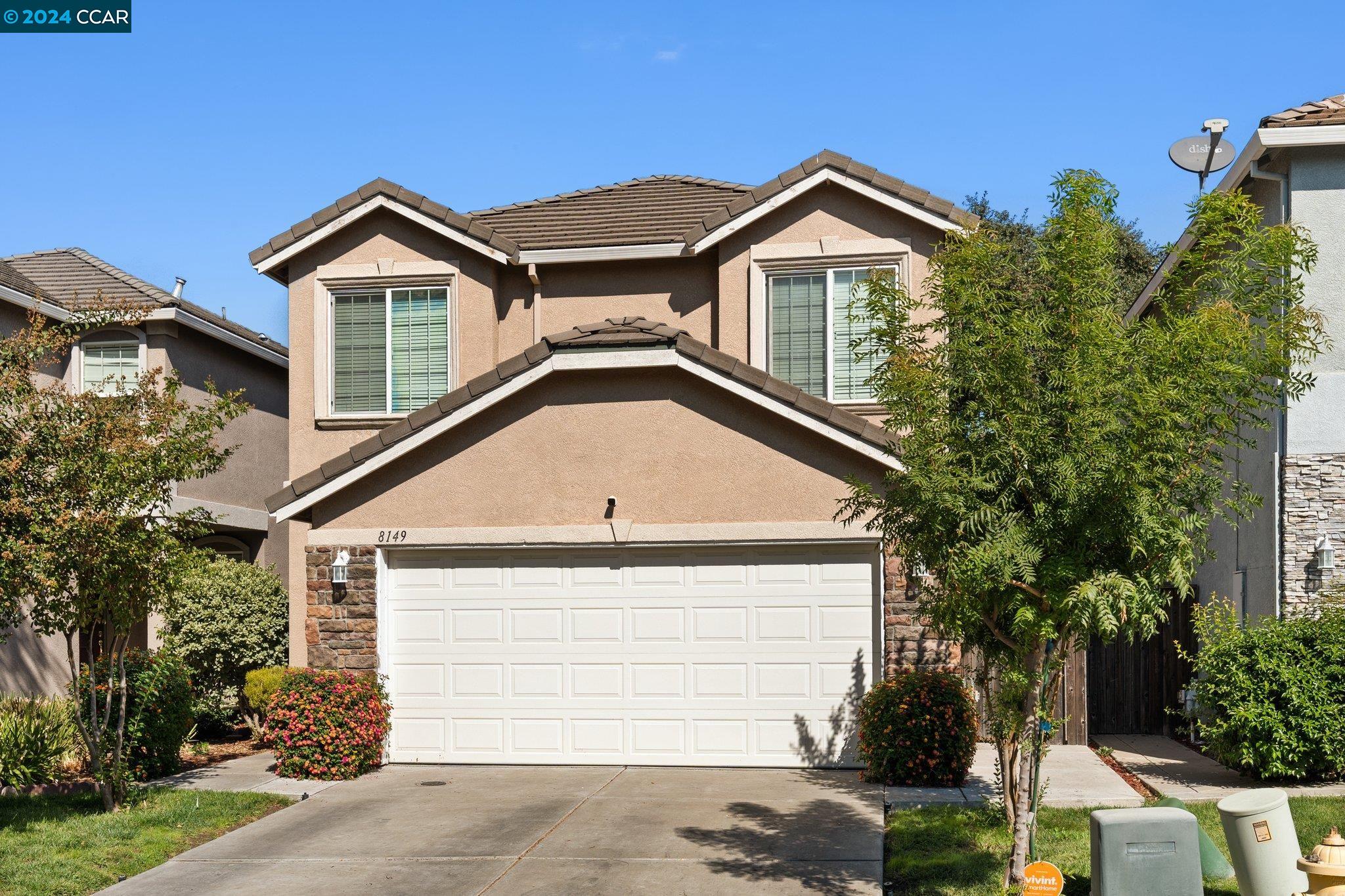 a front view of a house with a yard and garage