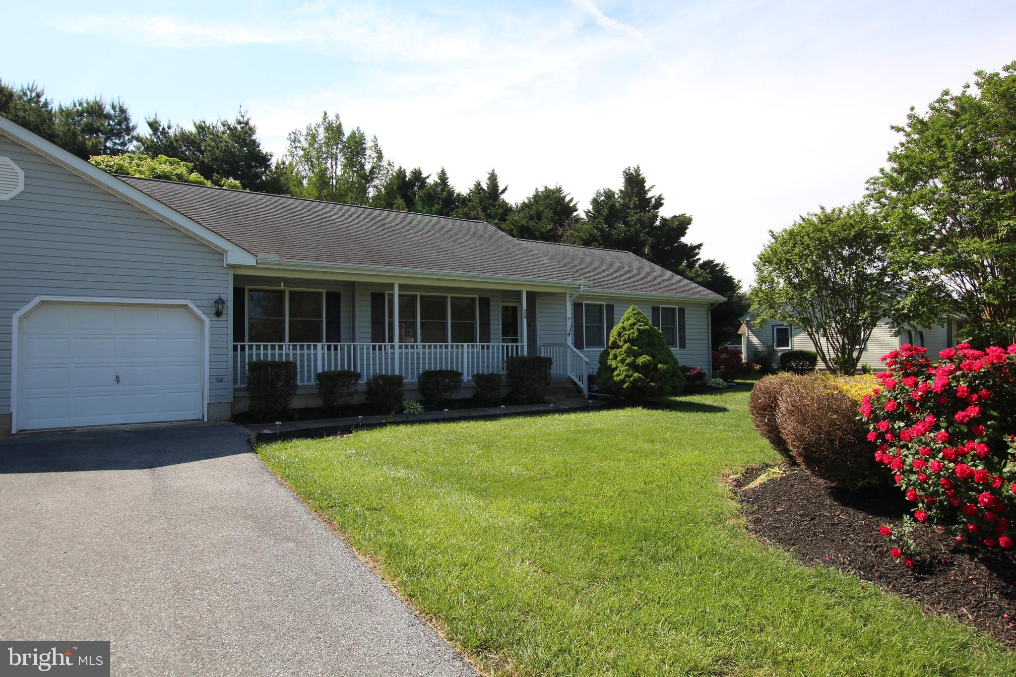 a front view of a house with a yard and trees