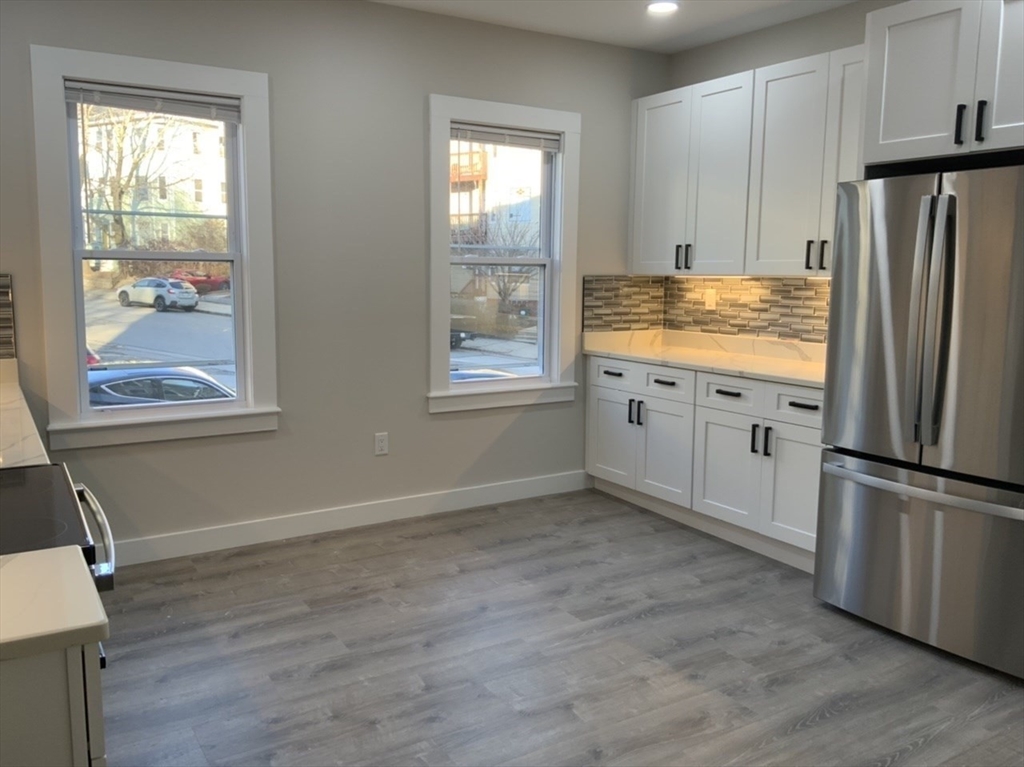 a view of kitchen with wooden floor electronic appliances and window