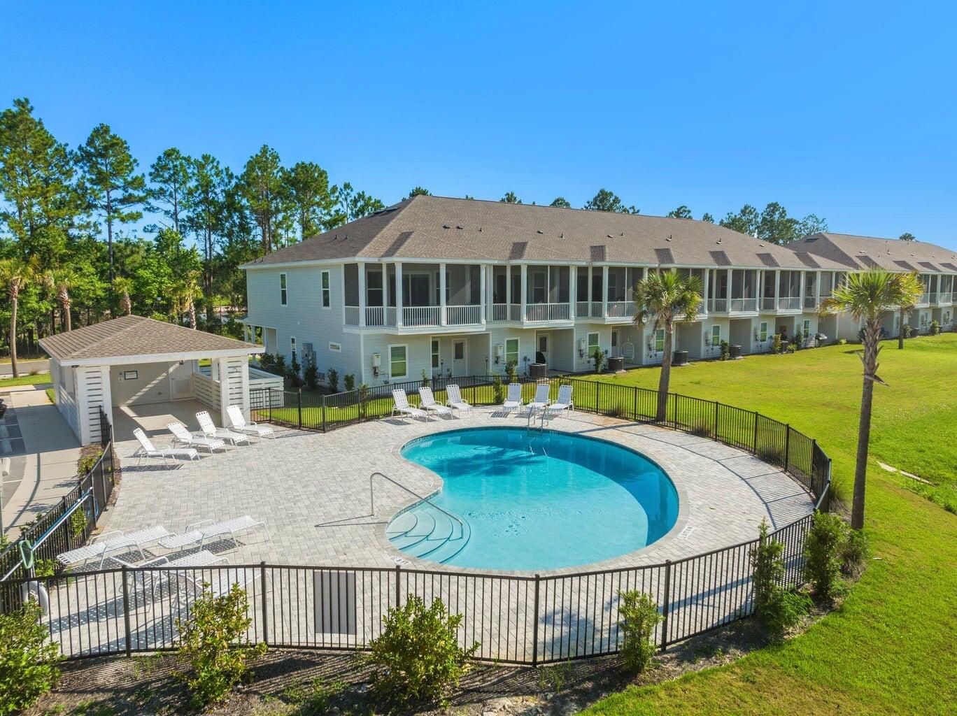 a view of a house with pool and chairs