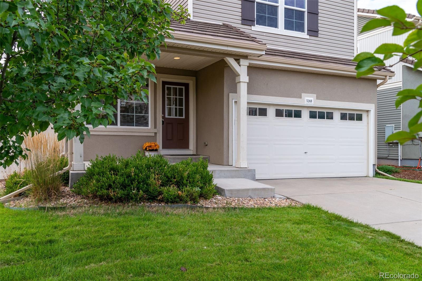 a front view of a house with a yard and garage